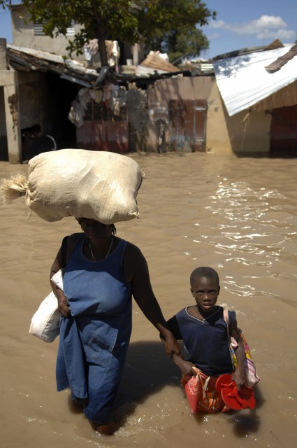 Kovan onnen Haiti! Tässä haitilaisäiti on saanut ruoka-apua 2008 hurrikaanin jälkeisissä tulvissa. 2010 saari kohtasi valtaisan humanitäärisen kriisin, kun maanjäristys runteli sitä. Jälleenrakennus on edelleen kesken, ja nyt trooppinen hirmumyrsky Matthew teki pahaa tuhoa saarivaltiossa.